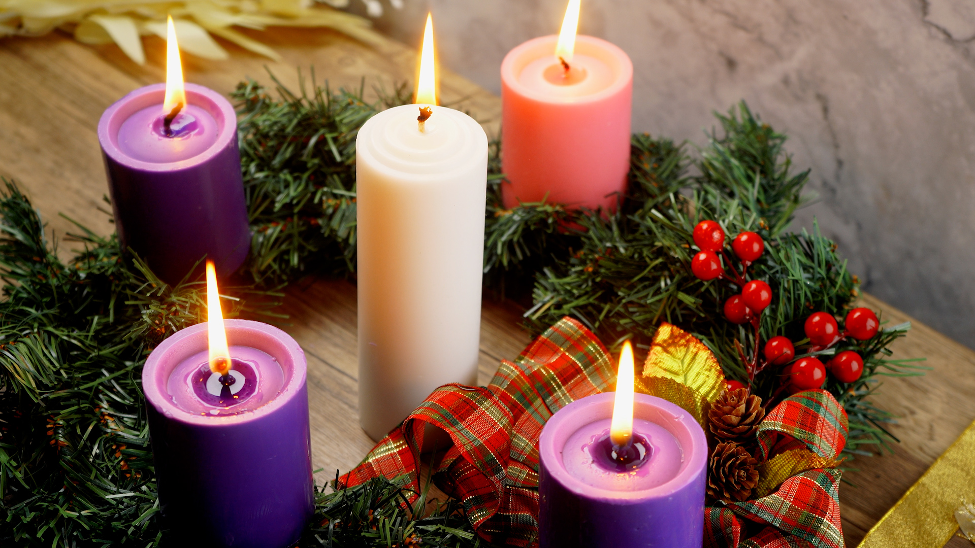 An Advent wreath with four purple and one white candle